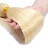 A bundle of #613 blonde straight high quality virgin human hair extensions tied with a yellow elastic band