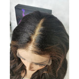 Black wavy human hair lace front wig with subtle highlights and natural part on fitted cap ear tap kinky wave design