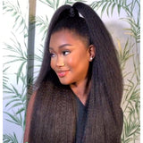 A woman wearing a lagos m-shaped hairline 13x6 hd lace front wig with kinky straight black hair in a high ponytail